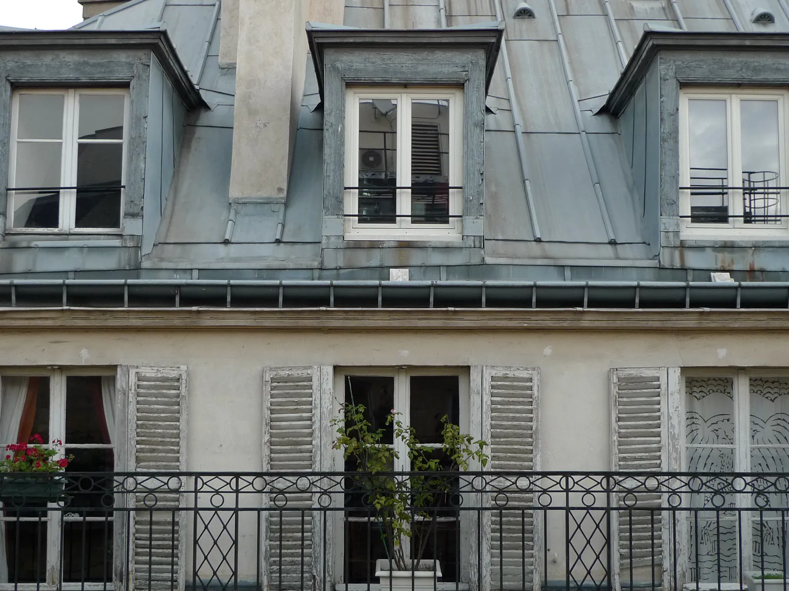 Toiture et gouttière en zinc d’un immeuble parisien, surface gris mat marquée par la patine